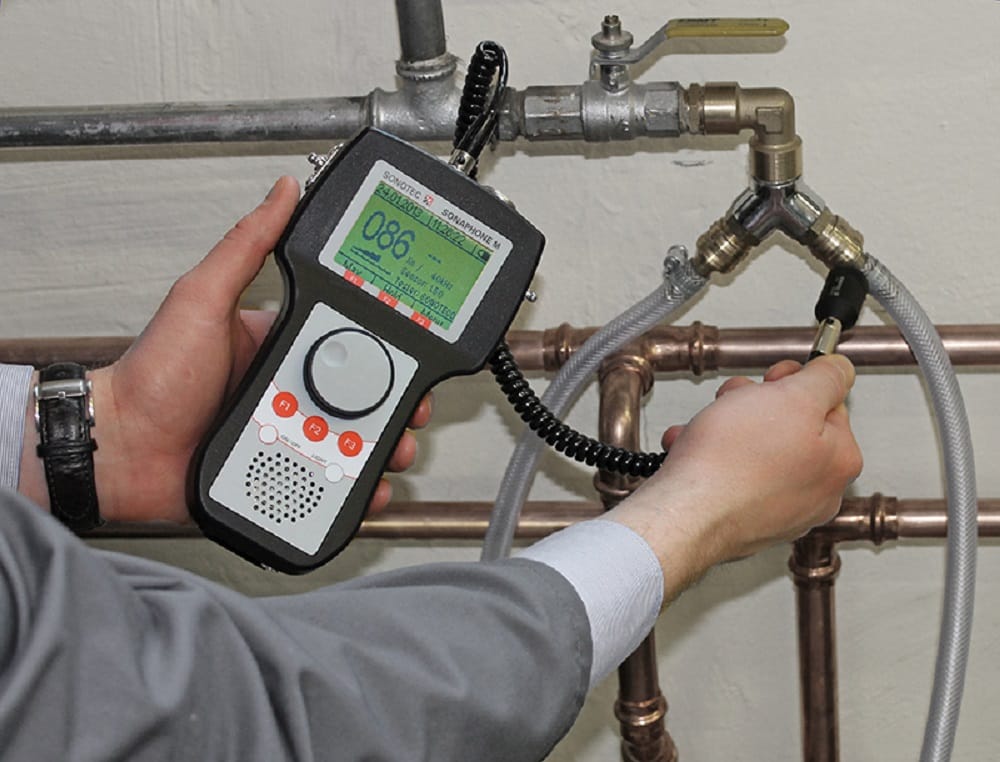 Plumber testing pipes with electronic leak detection equipment in Holly Springs