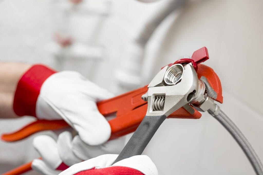 Plumber holding pipe wrenches for an emergency repair in Holly Springs