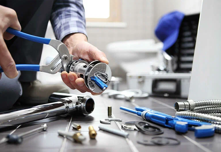 Technician repairing a plumbing fixture with professional tools in Holly Springs