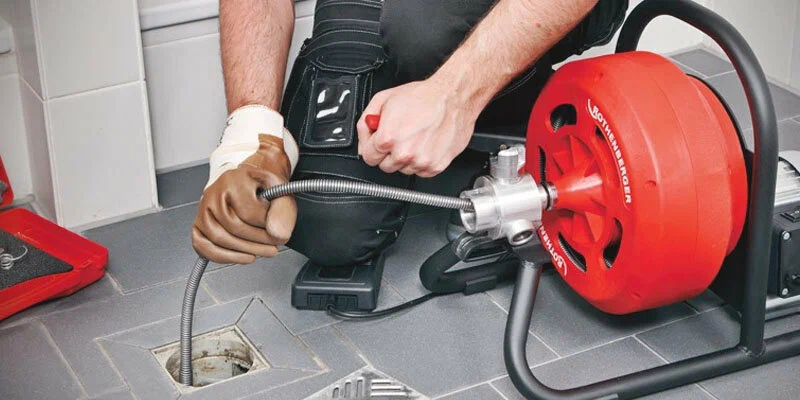 Plumber using a drain-cleaning machine in Holly Springs