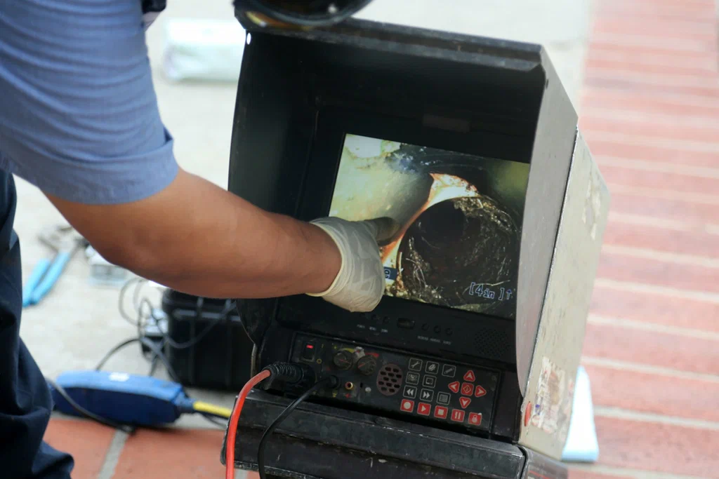 Technician viewing a drain inspection camera in Holly Springs