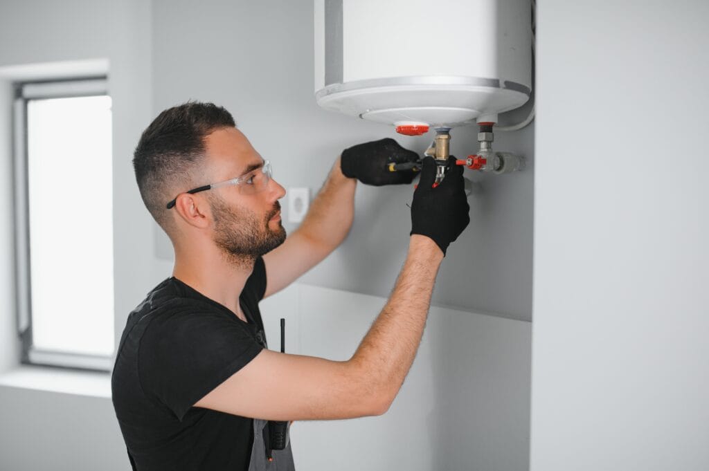 Technician performing water heater maintenance in Holly Springs