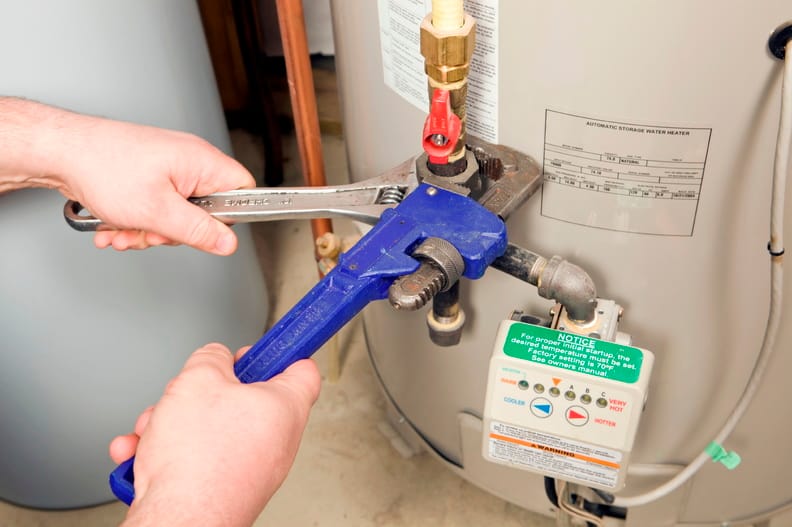 Plumber repairing a water heater valve in Holly Springs